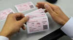 工作人员在查看打印出的测试车票。 - News.Sina.com.Cn