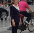 2014年，周华(化名)在女儿陪伴下于王府井大街游玩。 - News.Sina.com.Cn