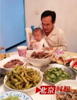 张少军抱着孙女的照片 图/北京时间 - News.Sina.com.Cn
