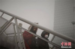 　　↑12月4日，戴着口罩的行人从天桥上走过。天津市气象台当日7时发布大雾橙色预警信号，天津大部分地区笼罩在大雾中，局部地区能见度低于200米。 - News.Sina.com.Cn
