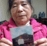 包玉贞拿着丈夫范安银的遗照。图/北京时间 - News.Sina.com.Cn