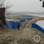 围堰周围竖起蓝色的钢板以防有人进入围堰，围堰外围不时也有执勤人员在巡逻。 - News.Sina.com.Cn