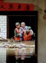 武警战士身背老人离开被淹的房子。 - News.Sina.com.Cn