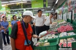 资料图：食品安全义工队员在衢州一超市对食品的生产日期进行检查 问泽英 摄 - Sc.Chinanews.Com.Cn