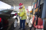 资料图：山西太原，加油站工作人员正在给车辆加油。 张云 摄 - Sc.Chinanews.Com.Cn