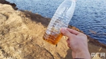 记者用矿泉水瓶盛出一些坑内的水体，呈半透明的棕色，气味更加明显。((央广记者 白杰戈 王逸群 摄)) - News.Sina.com.Cn