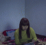 资料图：2016年3月29日，Sophorn坐在床上一边叠衣服一边玩手机。她正在收拾要带回柬埔寨的行李。图片来源：澎湃新闻 - News.Sina.com.Cn