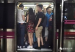 ▲地铁车厢内，被男乘客团团包围的女乘客。      新京报记者 大路 摄 - News.Sina.com.Cn