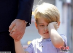 乔治小王子牵着爸爸的手，看起来睡意朦胧，不停揉眼。 - Sc.Chinanews.Com.Cn