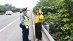 民警拦下在应急车道上行走的女子。 “成都交通运输”微博 图 - News.Sina.com.Cn