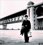1958 年11 月初，18岁的雷锋被鞍钢录用，穿着“时尚”的雷锋，微笑着站在雄伟的桥头堡下。 /中铁大桥局供图 - News.Sina.com.Cn