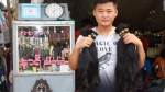 一位头发买家手里拿着他从仰光永盛市场买来的两束头发。 - News.Sina.com.Cn