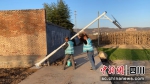 “点亮乡村·光明万家”项目工作人员在安装路灯。 王迪 - Sc.Chinanews.Com.Cn