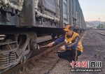 李世康在检查翻卸煤炭后的车辆状态。成都北车辆段供图 - Sc.Chinanews.Com.Cn