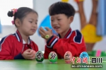 在幼儿园内，小朋友在玩“春分立蛋”游戏。彭圣洲 摄 - Sc.Chinanews.Com.Cn