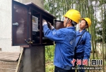 供电人员正在为农户接电抽水。邓耀平摄 - Sc.Chinanews.Com.Cn