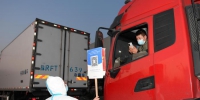 工作人员举牌让货车司机扫码。　王刚 摄 - News.Sina.com.Cn