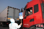 工作人员举牌让货车司机扫码。　王刚 摄 - News.Sina.com.Cn