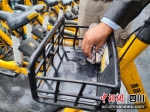 共享单车工作人员正在对喷漆小广告进行处理。 - Sc.Chinanews.Com.Cn