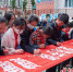 学生们在“爱路护路健康成长”横幅上签名。刘忠俊摄 - Sc.Chinanews.Com.Cn