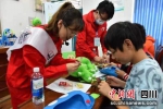志愿者教学生制作环保地球帽。李晋 摄 - Sc.Chinanews.Com.Cn