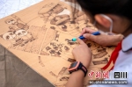 孩子们正在创作“烙铁”刻画。刘忠俊摄 - Sc.Chinanews.Com.Cn