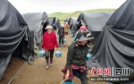 村民提着刚采摘的球盖菇走出大棚。高磊摄 - Sc.Chinanews.Com.Cn