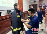 小朋友们现场体验消防服着装。德阳消防供图 - Sc.Chinanews.Com.Cn