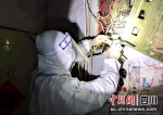 身穿防护服的电力工人正在检修某小区配电箱。王瀚摄 - Sc.Chinanews.Com.Cn