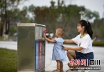 小朋友向垃圾桶扔垃圾。刘定春 摄 - Sc.Chinanews.Com.Cn
