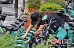 工作人员清除共享单车“牛皮癣”。 - Sc.Chinanews.Com.Cn