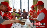 同心志愿服务队员和老人一起包粽子。彭圣洲 摄 - Sc.Chinanews.Com.Cn