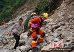 救援人员背着孩子通过危险塌方地带。四川消防供图 - Sc.Chinanews.Com.Cn