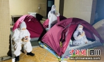 志愿者们在帐篷边抽空隙时间给家人视频。李鹏 摄 - Sc.Chinanews.Com.Cn