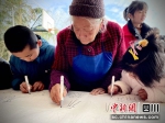 老人和孩子一起书写“福”字。洪雅融媒中心供图 - Sc.Chinanews.Com.Cn