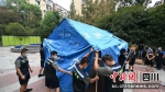 应急工作人员正在“疫”线搭建帐篷。舒兰摄 - Sc.Chinanews.Com.Cn