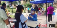 志愿者在查验核酸检测人员的健康码。人保财险成分 供图 - Sc.Chinanews.Com.Cn
