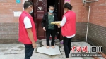 志愿者将采购物资送到居民手中。张登雄 摄 - Sc.Chinanews.Com.Cn