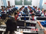 孩子们正在上音乐课。潘政吉 摄 - Sc.Chinanews.Com.Cn