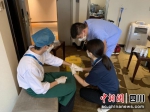 范双民与李凤为受外伤的工作人员进行治疗处理。 - Sc.Chinanews.Com.Cn