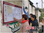 村民在公示牌前查看。罗江区委宣传部供图 - Sc.Chinanews.Com.Cn