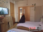 老人在供暖房间看电视。 - Sc.Chinanews.Com.Cn