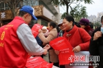 工作人员发放创文宣传手袋。姜晓凤 摄 - Sc.Chinanews.Com.Cn
