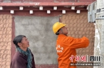 电力运维人员正在检查村民电表等。洛泽仁摄 - Sc.Chinanews.Com.Cn