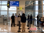 成都边检移民管理警察在登机口监护。(张鹏波摄) - Sc.Chinanews.Com.Cn