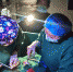 手电灯光下张艺霁与医护人员正在为患者缝合伤口。成都市中西医结合医院（市一医院）供图 - Sc.Chinanews.Com.Cn