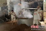 工人们正在翻炒酿酒用的粮食。绵竹市融媒体中心供图 - Sc.Chinanews.Com.Cn