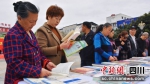 市民在书摊前阅读。 中江县委宣传部供图 - Sc.Chinanews.Com.Cn