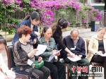 活动现场工作人员指导群众填写调查问卷。王稀 摄 - Sc.Chinanews.Com.Cn