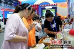 参观者在甘孜馆品尝高原饮品。小红摄 - Sc.Chinanews.Com.Cn